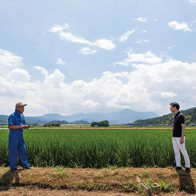 宮﨑さん(右)が営む「梅乃井」のために、吉村康義さん(左)が作っている水田の前