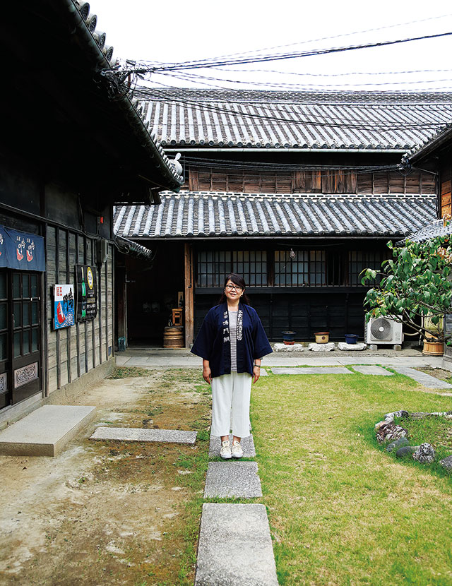 本家松浦酒造場の中庭に笑顔で立つ、10代目蔵元の松浦素子さん